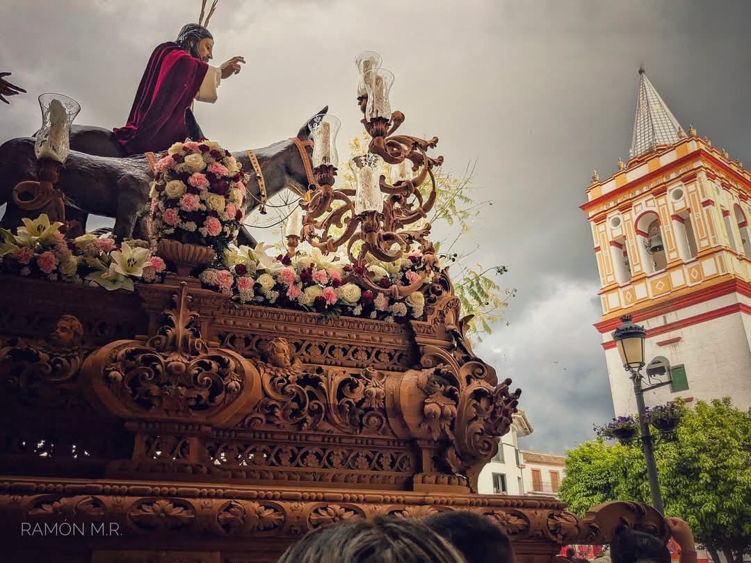 Detalle del paso de misterio con la torre de la iglesia al fondo